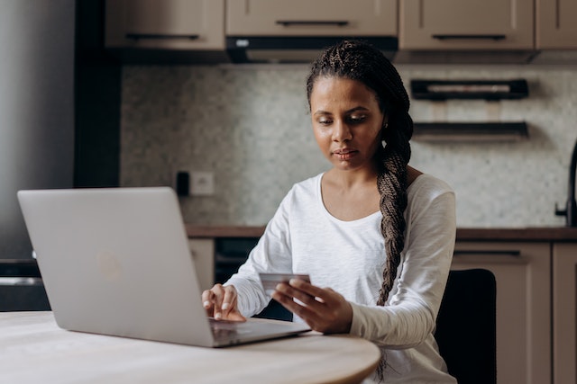 person holding a credit card and making an online payment